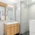 Bathroom with floating sink, black tiles and glass shower door