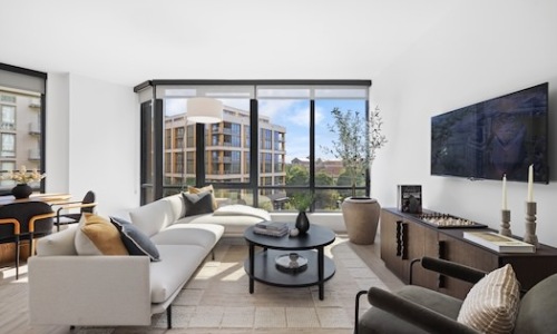 a living room with a couch and a table and large windows