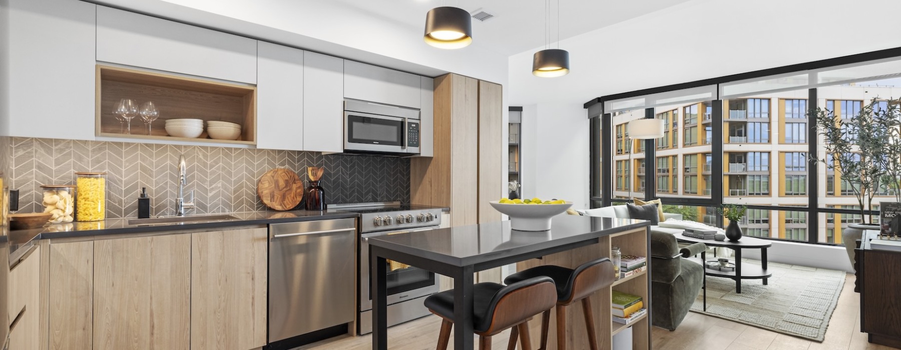 Kitchen with dark back splash and light cabinets, and floor to ceiling windows