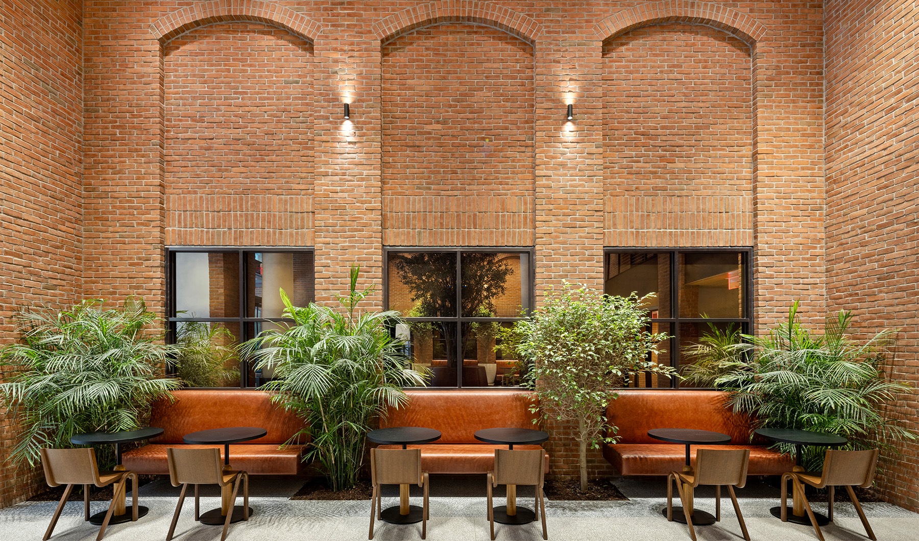 The essence of exceptional living a room with tall ceilings, brick walls and leather seating
