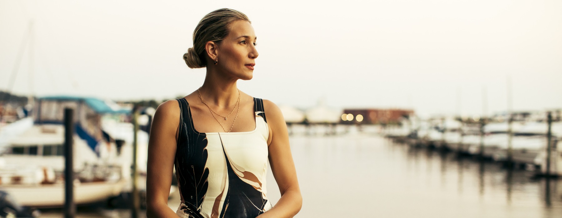 A woman standing on the dock of a marina