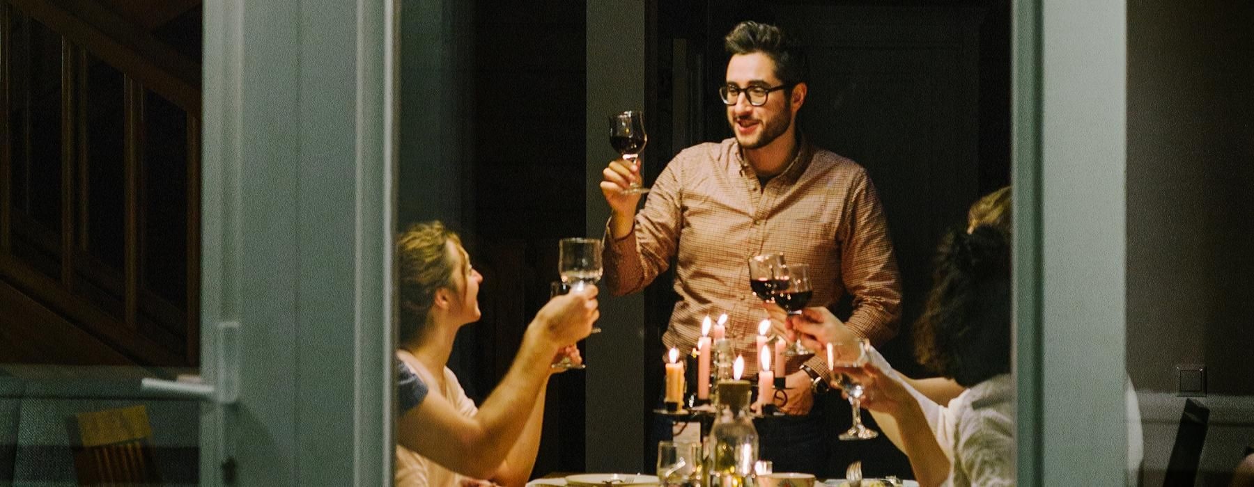 a group of people sitting at a table with food and drinks